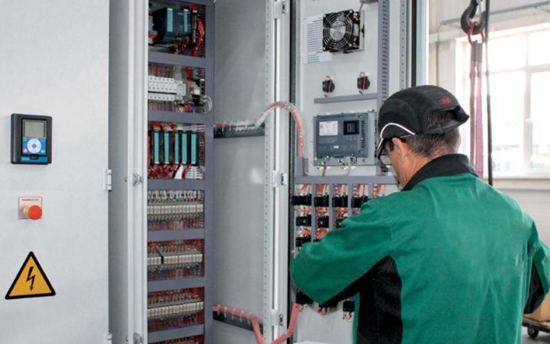 Technician manufacturing an electrical distribution and control cabinet